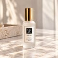 Maison Fragrance Scent 031 Linen Mist, 100 ml, in a matte white bottle with a cylindrical gold cap and official CL monogram, on beige marble in soft natural light.