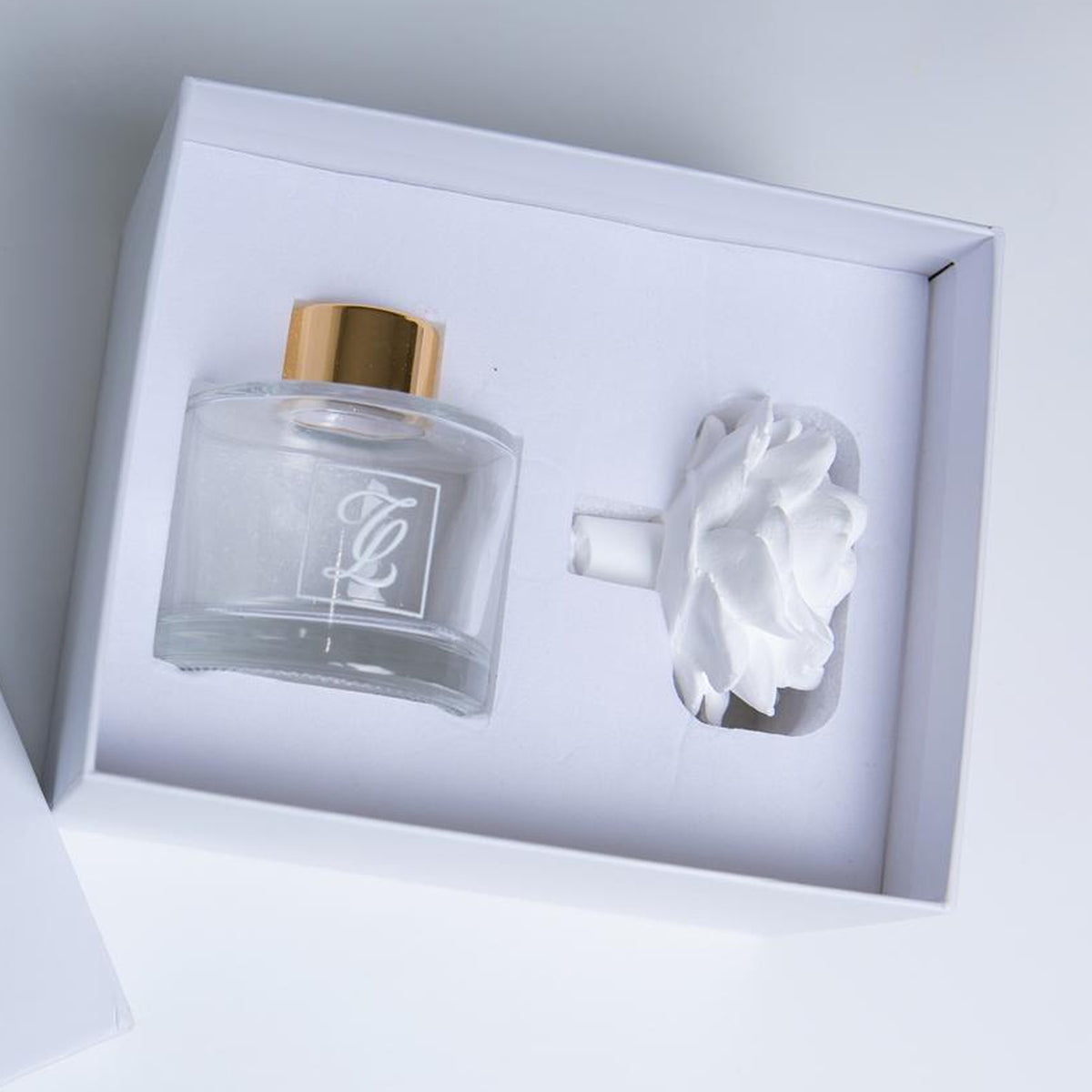Maison Fragrance Ceramic Diffuser with a gold-capped glass bottle and white ceramic flower in a white presentation box.