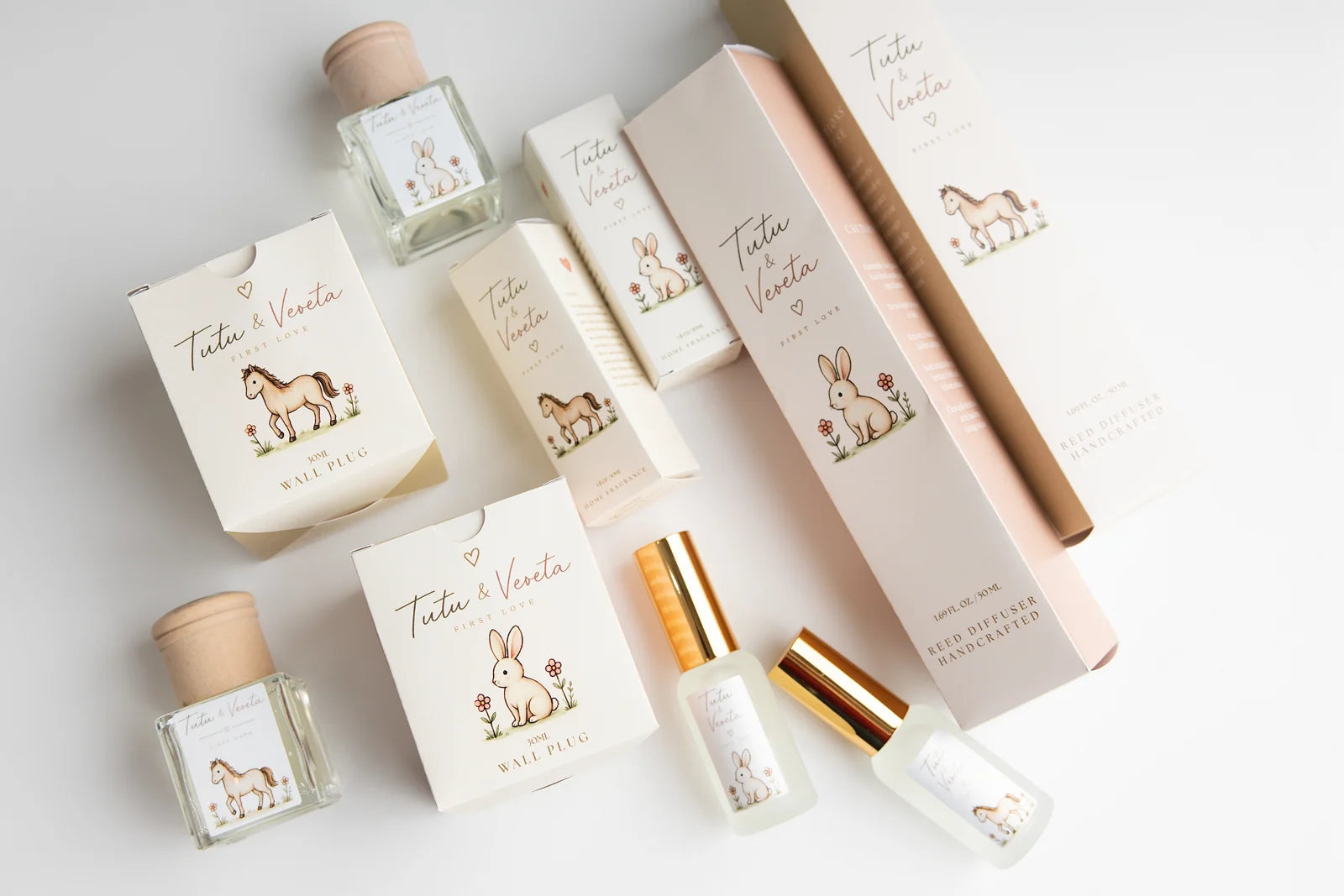 Original First Love fragrance bottles and illustrated packaging photographed on an ivory surface
